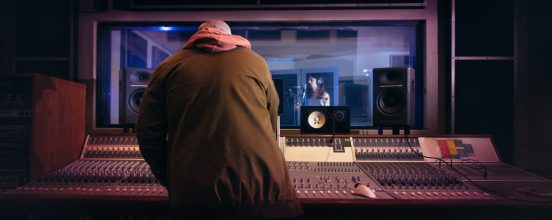 Photograph of a singer and a sound engineer, both working.